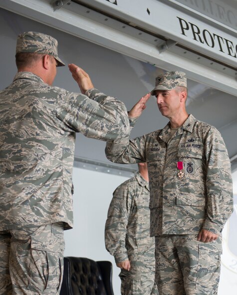 U.S. Air Force Col. Paul Kasuda (right) receives a Legion of Merit award certificate from Col. Samuel Milam, 93d Air and Ground Operations Wing commander, during an 820th Base Defense Group change of command ceremony at Moody Air Force Base, Ga., June 20, 2014. Kasuda has served as the 820th BDG commander for two years and is returning to Joint Base San Antonio-Lackland,Texas, to work at the Security Forces Center. (U.S. Air Force photo by Airman Dillian Bamman/Released)