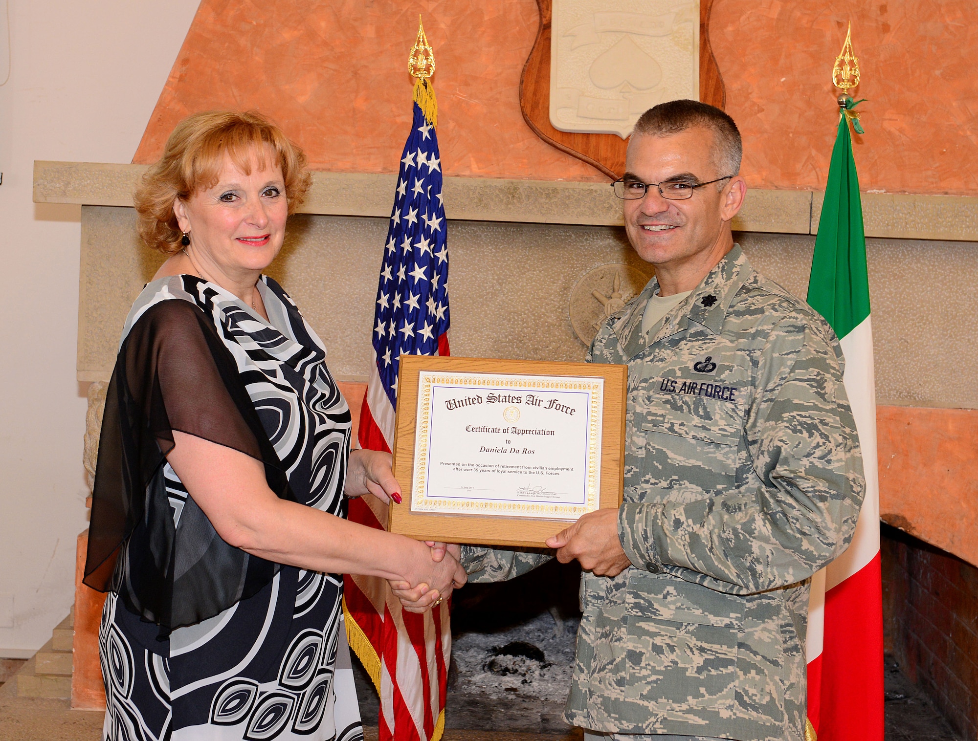 Lt. Col. Carlos Ramos, 31st Contracting Squadron commander, gives Daniela Da Ros, 31st CONS quality assurance program coordinator, a retirement certificate at her retirement ceremony, June 20, 2014, at Aviano Air Base, Italy. In recognition of her achievement, Ramos presented Da Ros with a certificate of retirement. (U.S. Air Force photo/Senior Airman Matthew Lotz)