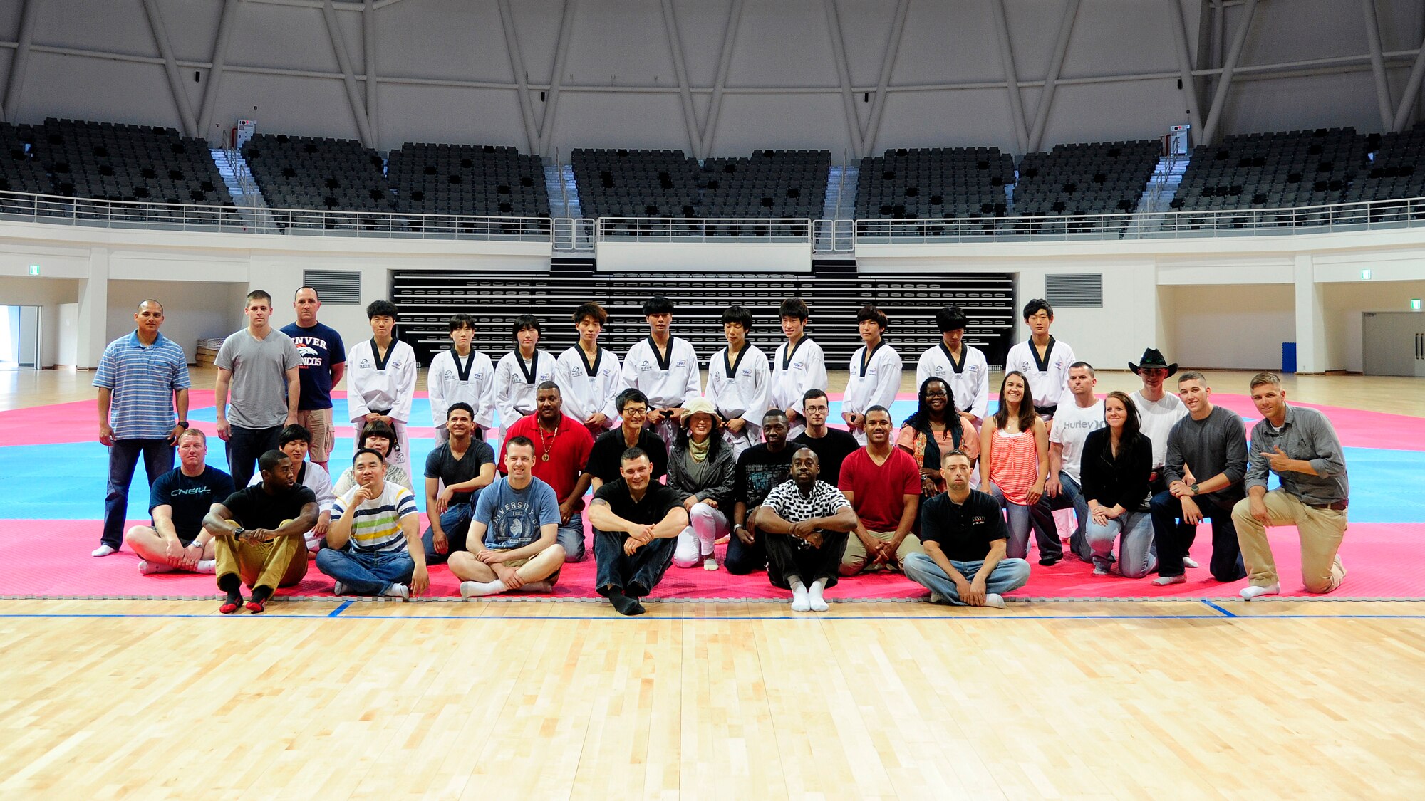 Twenty-two Airmen from Kunsan Air Base pose for a group photo with students of the Taekwondowon Center in Muju, Republic of Korea, June 11, 2014. The students gave a demonstration of taekwondo to the members of Kunsan during a tour of the center. The tour gave American service members a better understanding of South Korean culture and built a better relationship between the two countries. (U.S. Air Force photo by Senior Airman Taylor Curry/Released) 