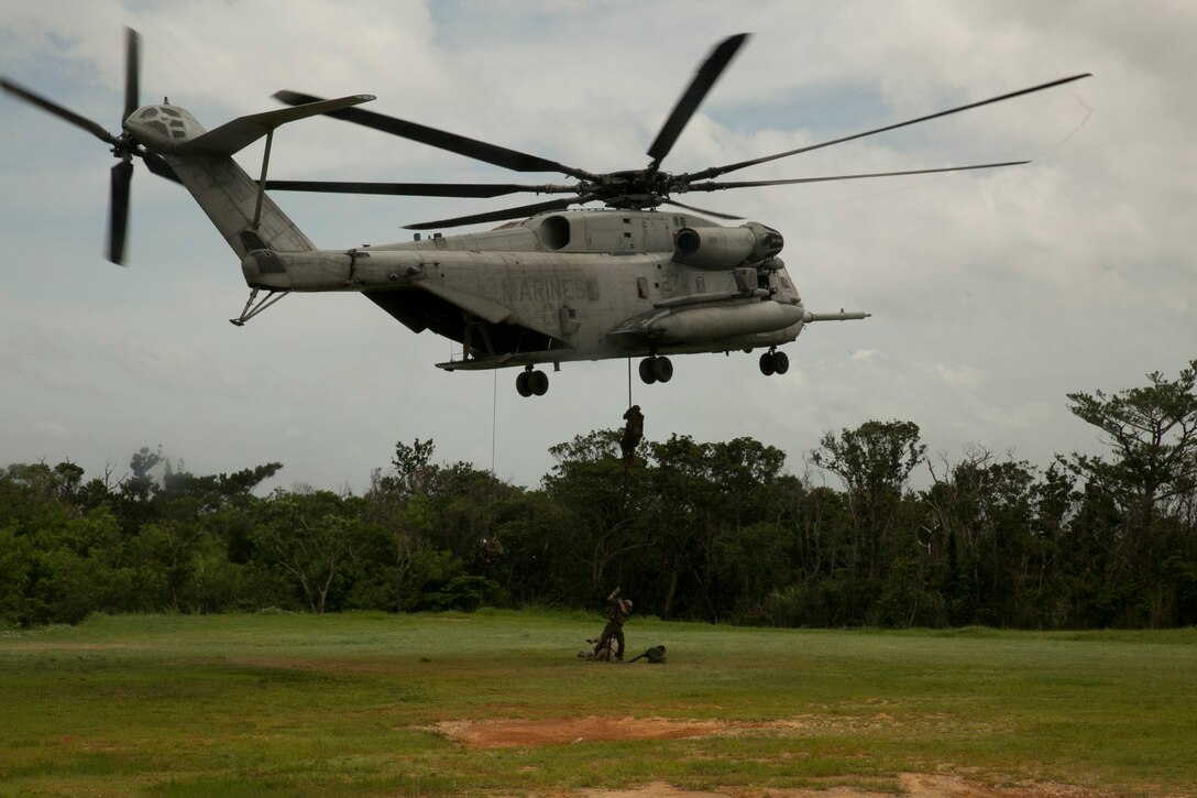 Marines execute fast-rope training out of an inflight CH-53E Super Stallion helicopter June 17 at the Central Training Area near Camp Schwab. The training began at Marine Corps Air Station Futenma, where the aircrew flew the helicopter to the recon Marines at the Central Training Area. The aircrew Marines are with Marine Heavy Helicopter Squadron 361, currently assigned to Marine Aircraft Group 36, 1st Marine Aircraft Wing, III Marine Expeditionary Force, under the unit deployment program. The recon Marines are with Force Reconnaissance Company, 3rd Reconnaissance Battalion, 3rd Marine Division, III MEF.  (U.S. Marine Corps photo by Lance Cpl. Brittany A. James/Released)