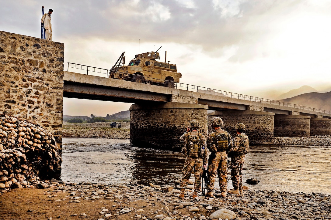U.S. Air Force Capt. Jon Polston and Air Force 1st Lt. Scott Adamson inspect the underside of the Jugi bridge as traffic squeezes through the narrow roadway in Mehtar Lam in Laghman province, Afghanistan, Sept. 7, 2011. Polston and Adamson are engineers assigned to the Laghman Provincial Reconstruction Team.  
