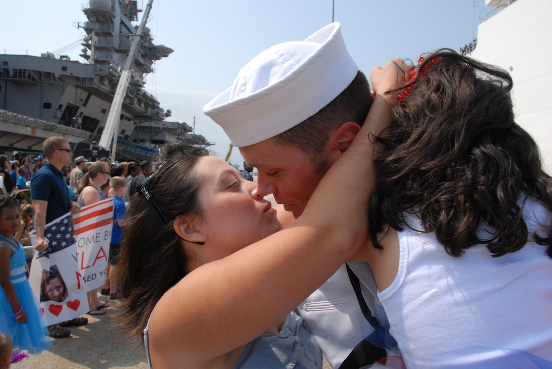 Navy Petty Officer 2nd Class Mike Leslie hugs his wife and child after disembarking from the Military Sealift Command hospital ship USNS Comfort at Naval Station Norfolk, Va., Sept. 2, 2011. The Comfort was deployed as the primary hospital ship for Continuing Promise 2011, a five-month humanitarian assistance mission that visited nine countries in Central and South America and the Caribbean. 