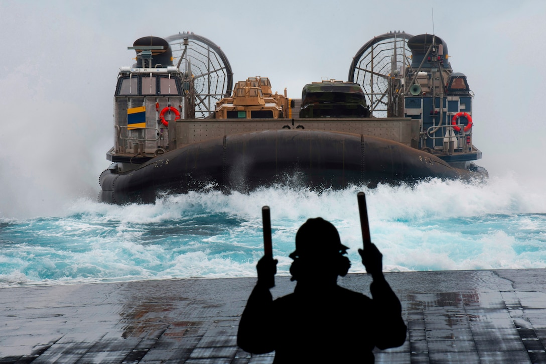 A U.S. Navy sailor guides a Landing Craft Air Cushion (LCAC) as it approaches the amphibious transport dock ship USS New Orleans in the Pacific Ocean, Sept. 4, 2011. New Orleans and embarked Marines assigned to the 11th Marine Expeditionary Unit are conducting a composite training unit exercise. 