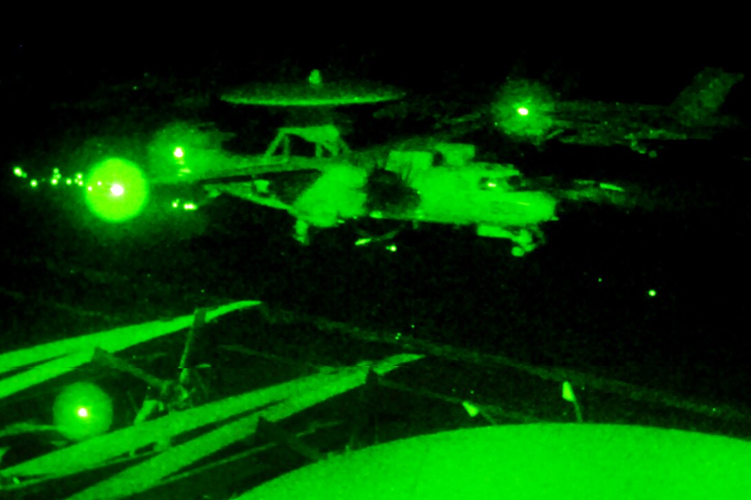 As seen through a night-vision device, an E-2C Hawkeye makes an arrested landing on the flight deck of the aircraft carrier USS George H.W. Bush, marking the ship's 20,000th trap in the Arabian Sea, Aug. 23, 2011. The Hawkeye crew is assigned to the Carrier Airborne Early Warning Sqaudron 124. 
