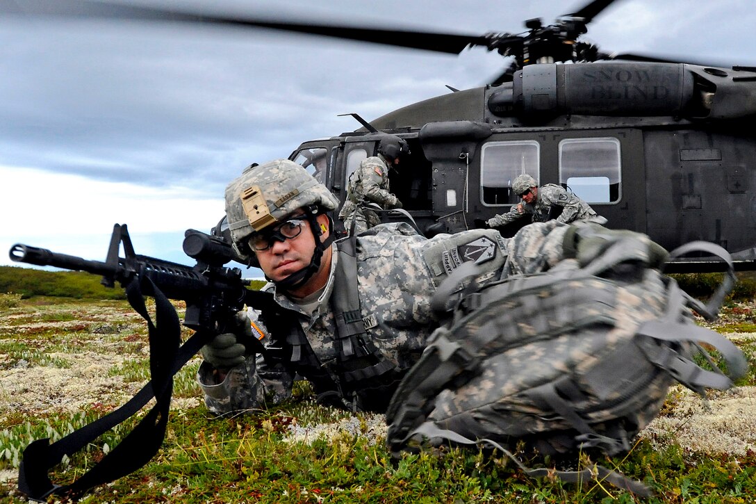 Army 1st Sgt. Gerald Eagan throws his rucksack in front of him while pulling security detail during a heliborne insertion mission as part of the Order of the Arctic Sapper competition on Joint Base Elmendorf-Richardson, Alaska, Aug. 17, 2011. Eagan is assigned to the 6th Engineer Battalion. 