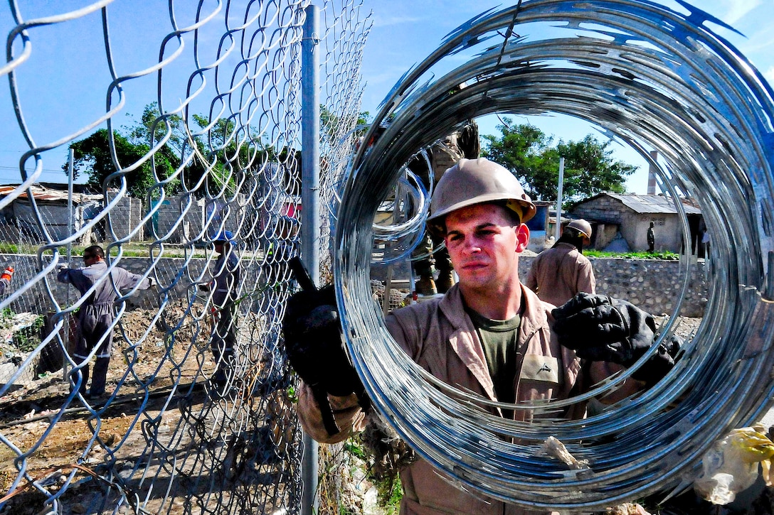 U.S. Marine Corps Lance Cpl. Steven Cole unravels razor wire at the Esaie Jeanty Hospital Cite Soleil engineering site during Continuing Promise 2011 in Port-au-Prince, Haiti, Aug. 20, 2011. Continuing Promise is a five-month humanitarian assistance mission to the Caribbean, Central and South America. 