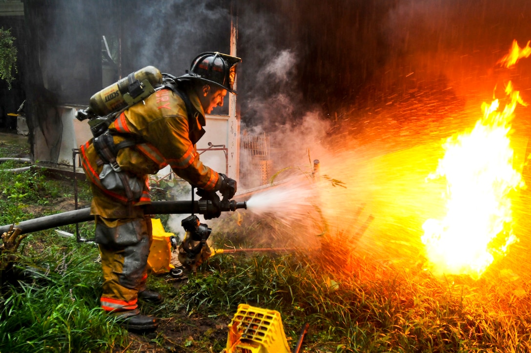 Army Pvt. 1st Class Lucas Ternell puts out a small debis fire in a yard in Salisbury, Md., Aug. 27, 2011. Ternell is a volunteer firefighter assigned to the 20th Military Police Company, Maryland National Guard. Ternell was aboard Rescue 16, one of several fire and rescue engines that reported to the fire inside a residential neighborhood. Guard members are providing support during the Hurricane Irene response. 