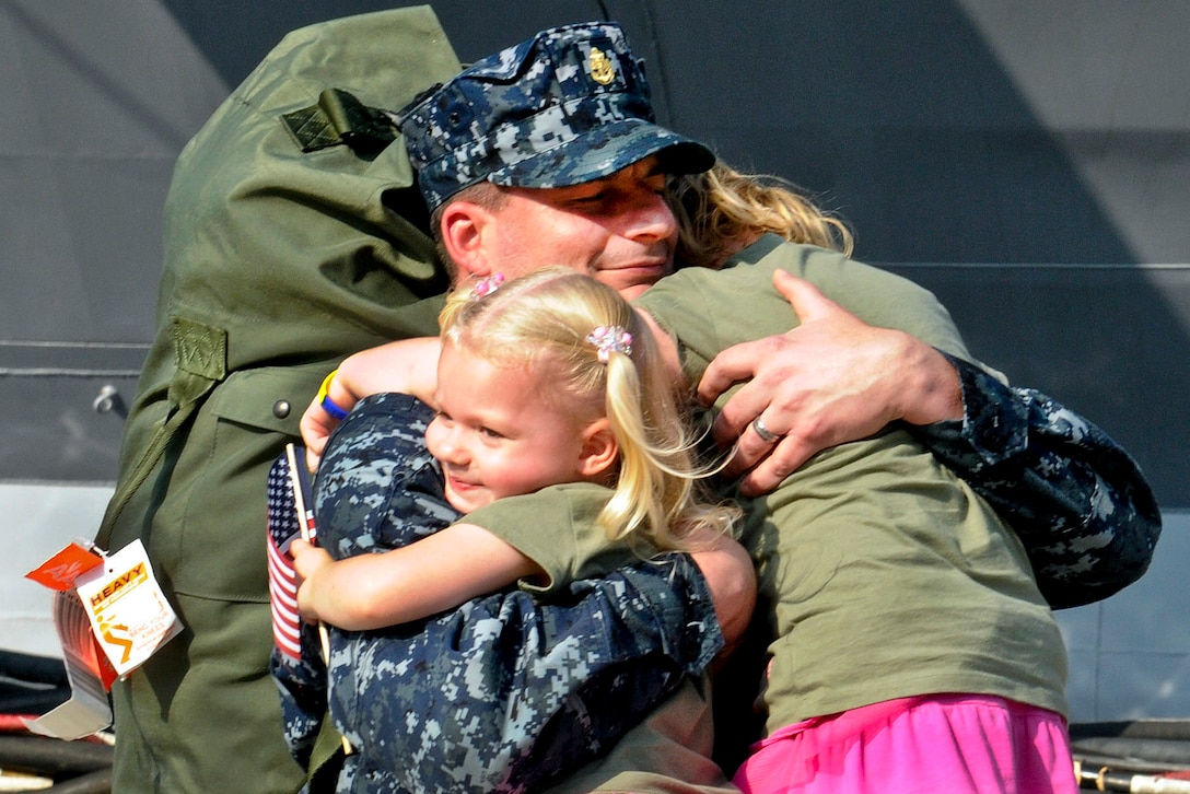 U.S. Navy Chief Petty Officer Marc De St. Aubin hugs his daughters after the U.S. 7th Fleet command ship USS Blue Ridge arrives at Commander, Fleet Activities Yokosuka, Japan, Aug. 29, 2011. The Blue Ridge returned to Yokosuka after a two-month patrol throughout the Pacific region. De St. Aubin is an intelligence specialist. 