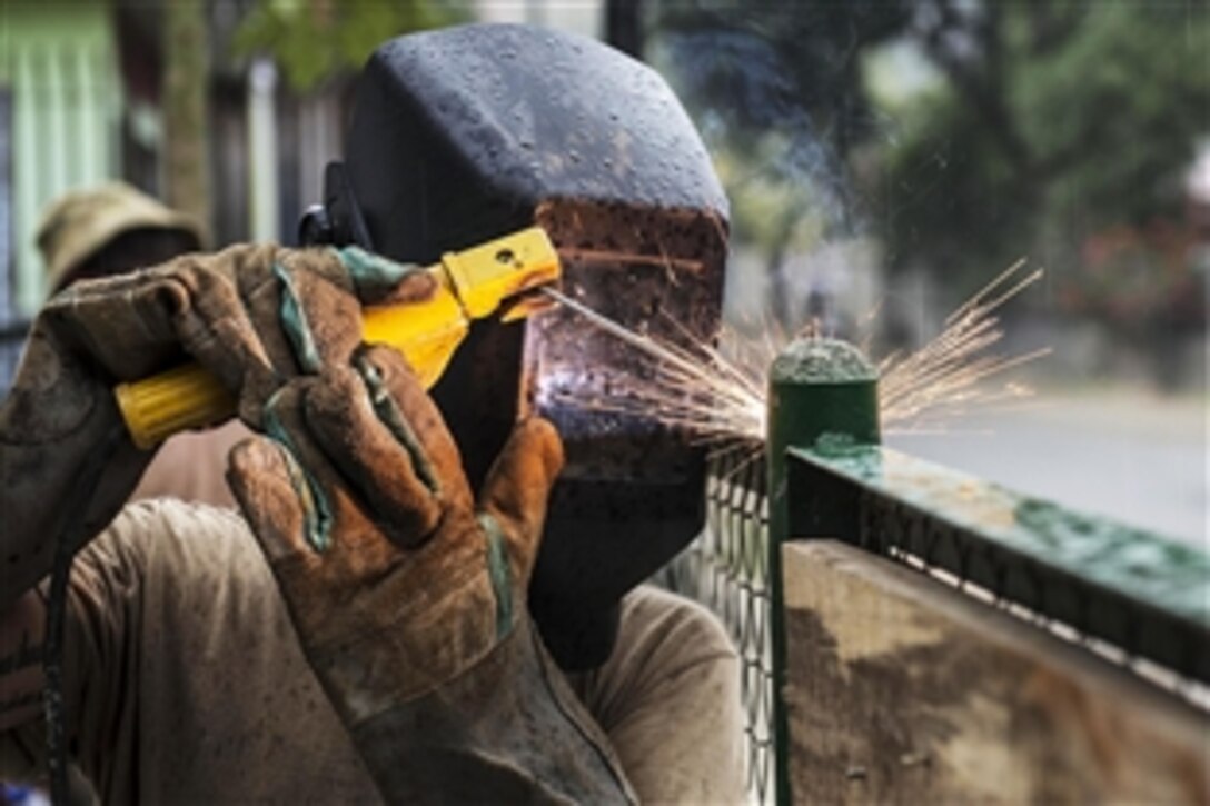 U.S. Navy Petty Officer 3rd Class Lori Hill secures a fence during an engineering project at Comoro Medical Center in support of Pacific Partnership 2014 in Dili, Timor-Leste, June 21, 2014. Pacific Partnership is in its ninth year and is the largest annual multilateral humanitarian assistance and disaster relief preparedness mission conducted in the Asia-Pacific region.
