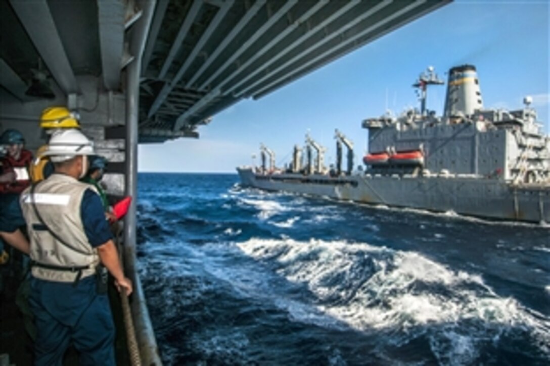 U.S. sailors aboard the U.S. Navy aircraft carrier USS George Washington watch the USNS Walter S. Diehl steam alongside during a replenishment-at-sea in the South China Sea, June 23, 2014. The George Washington and its embarked air wing, Carrier Air Wing 5, provide a combat-ready force that protects and defends the collective maritime interest of the U.S. and its allies and partners in the Indo-Asia-Pacific region.