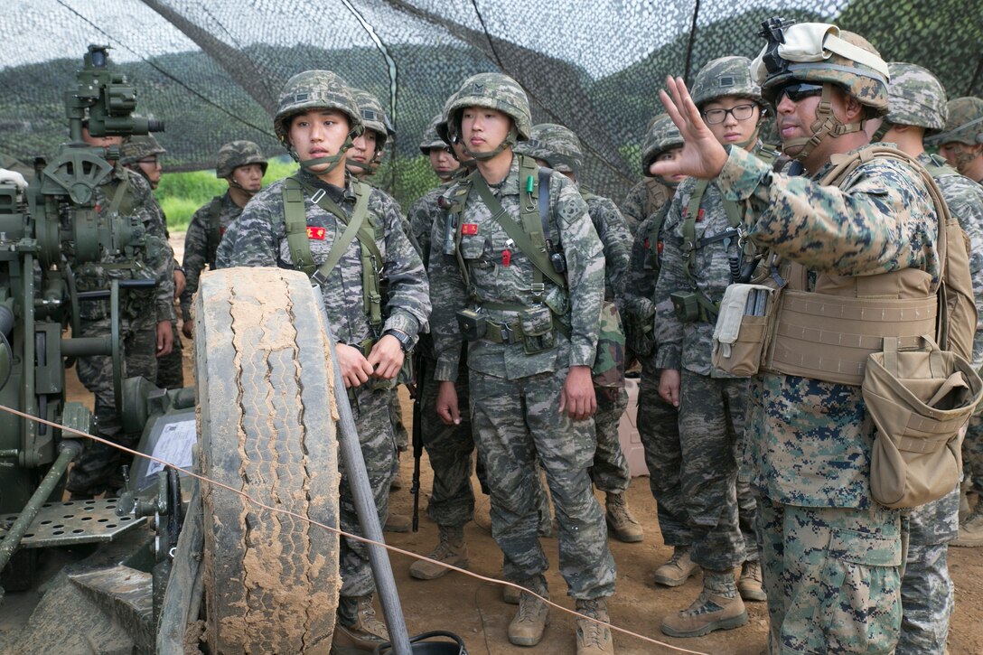 U.S. Marine Sgt. Michael D. Gutierrez, right, introduces the M777A2 lightweight 155 mm howitzer to Republic of Korea Marines June 12 at Warrior Base, Munsan, South Korea, during the Korean Marine Exchange Program 14-7. The U.S. Marines and ROK Marines are training together on an artillery live-fire range. KMEP 14-7 is one iteration in a series of continuous combined training exercises that enhance the ROK-U.S. alliance, promote stability on the Korean Peninsula, and strengthen ROK-U.S. military capabilities and interoperability. Gutierrez is a Detroit, Michigan, native and field artillery cannoneer with 3rd Battalion, 12th Marine Regiment, 3rd Marine Division, III Marine Expeditionary Force. (U.S. Marine Corps Photo by Lance Cpl. Thor J. Larson/ Released)