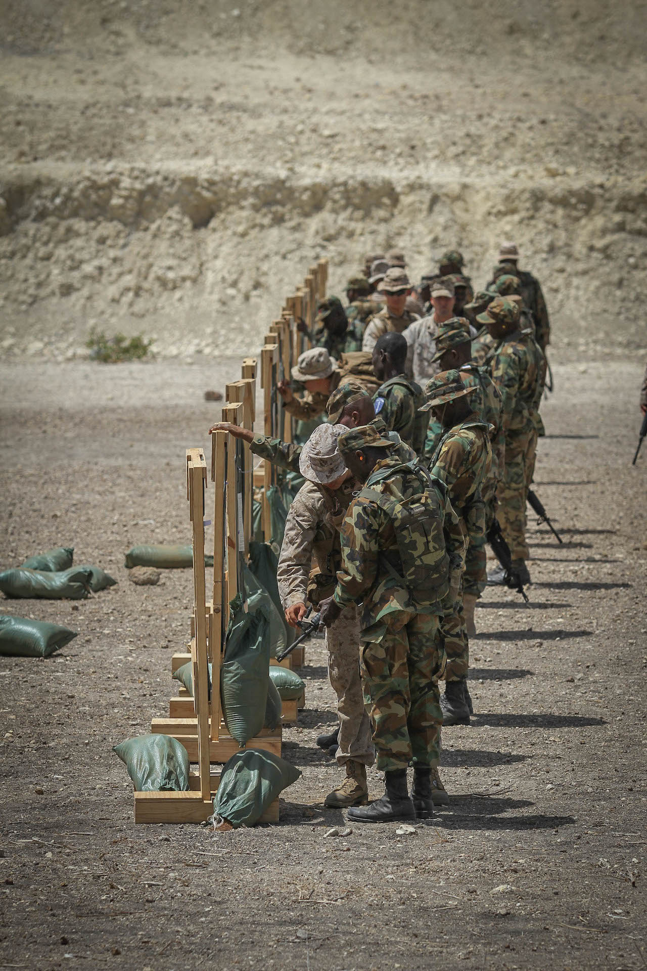 Marines with the 3rd Bn., 23rd Marine Regiment assist Ghanaian Soldiers in battle sight zeroing their weapons during a firing range June 19, 2014. The firing range was a part of Exercise Western Accord, a U.S. Africa Command sponsored annual joint training partnership exercise between the United States, the Economic Community of West African States and partner nations. The exercise, held in Senegal this year, is designed to increase interoperability between military forces and ensure the common ability to conduct peace operations throughout western Africa. (Photo by U.S. Army Staff Sgt. V. Michelle Woods/40th PAD)