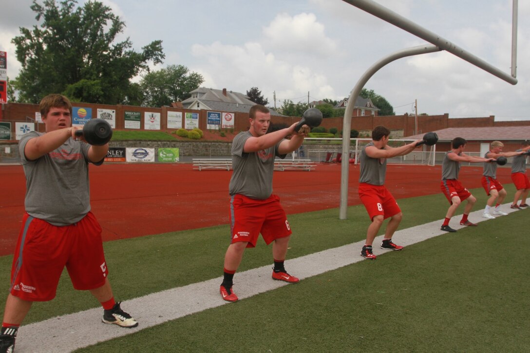 Members of the Parkersburg High School football team conduct kettle bell swings during the physical training portion of a leadership seminar held June 20, 2014. The seminar, held at Parkersburg High School in Parkersburg, W.Va., was conducted by Marines from Recruiting Station Charleston with the purpose of developing the leadership abilities of the football team by teaching Marine Corps values. (U.S. Marine Corps photo by Sgt. Tyler Hlavac/Released)