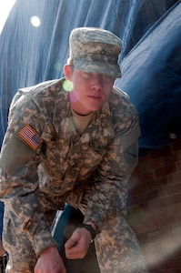 Kentucky National Guard Pfc. Kyle Gray, 301st Chemical Company, pulls nails out of a piece of plywood, March 6, 2012 during tornado relief efforts in West Liberty, Ky. Gray boarded up broken windows and holes for West Liberty resident Thomas Coder, a retired Air Force veteran, after a tornado damaged most of his home, March 2, 2012.