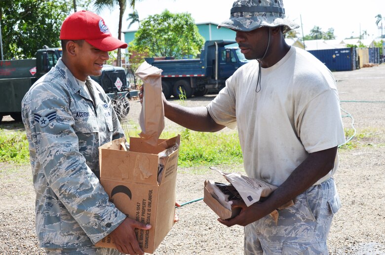 Senior Airman Mario Acevedo (left), a New Horizons services journeyman deployed from the 820th RED HORSE Squadron, Nellis Air Force Base, Nevada, issues MREs to Staff Sgt. Smette Pompfilius, New Horizons vehicle maintenance, June 24, 2014, in Ladyville, Belize. (U.S. Air Force photo/Master Sgt. Kelly Ogden)