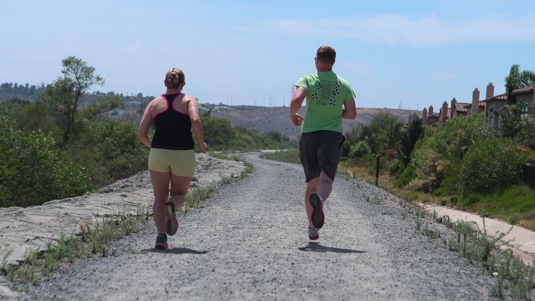 Corporal Dalton Pridmore, intelligence analyst, 15th Marine Expeditionary Unit, runs with his wife, Jamie Pridmore, in Oceanside, Calif., June 20, 2014. Pridmore and his wife are from Moody, Alabama. (U.S. Marine Corps photo by Lance Cpl. Anna Albrecht/Released)
