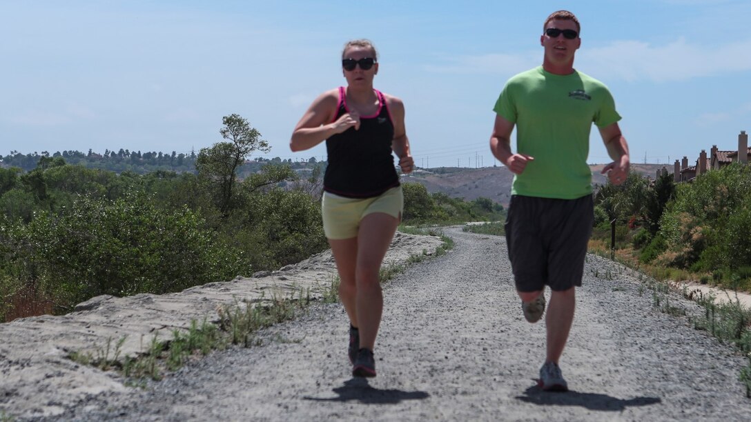 Corporal Dalton Pridmore, intelligence analyst, 15th Marine Expeditionary Unit, runs with his wife, Jamie Pridmore, in Oceanside, Calif., June 20, 2014. Pridmore and his wife are from Moody, Alabama. (U.S. Marine Corps photo by Lance Cpl. Anna Albrecht/Released)