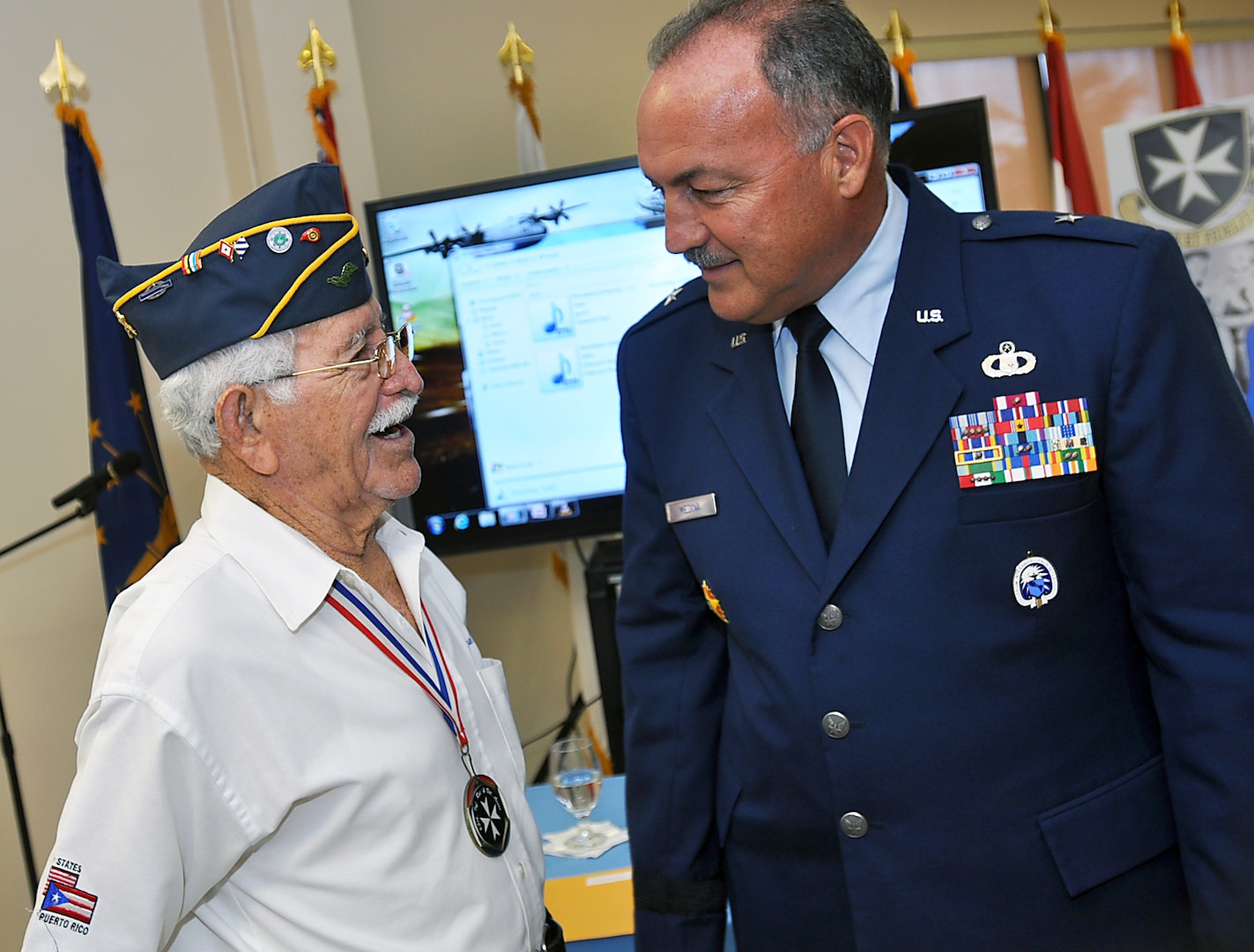 The adjutant general of Puerto Rico, Brig. Gen. Juan J. Medina Lamela, listens to the personal story of a veteran Borinqueneer after the roundtable The Borinqueneers: Then and Now: The Evolution of the 65th Infantry Regiment, in San Juan.