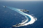 PACIFIC OCEAN (June 24, 2014) - View Caption Hide Caption The Arleigh Burke-class guided-missile destroyer USS Spruance (DDG 111), front, pulls away as the amphibious dock landing ship USS Rushmore (LSD 47) approaches the Military Sealift Command fast combat support ship USNS Rainier (T-AOE 7), center. The amphibious assault ship USS Peleliu (LHA 5) is conducting a replenishment-at-sea with Rainier. The ships are en route to participate in the Rim of the Pacific (RIMPAC) 2014 exercise from June 26 to Aug. 1. 