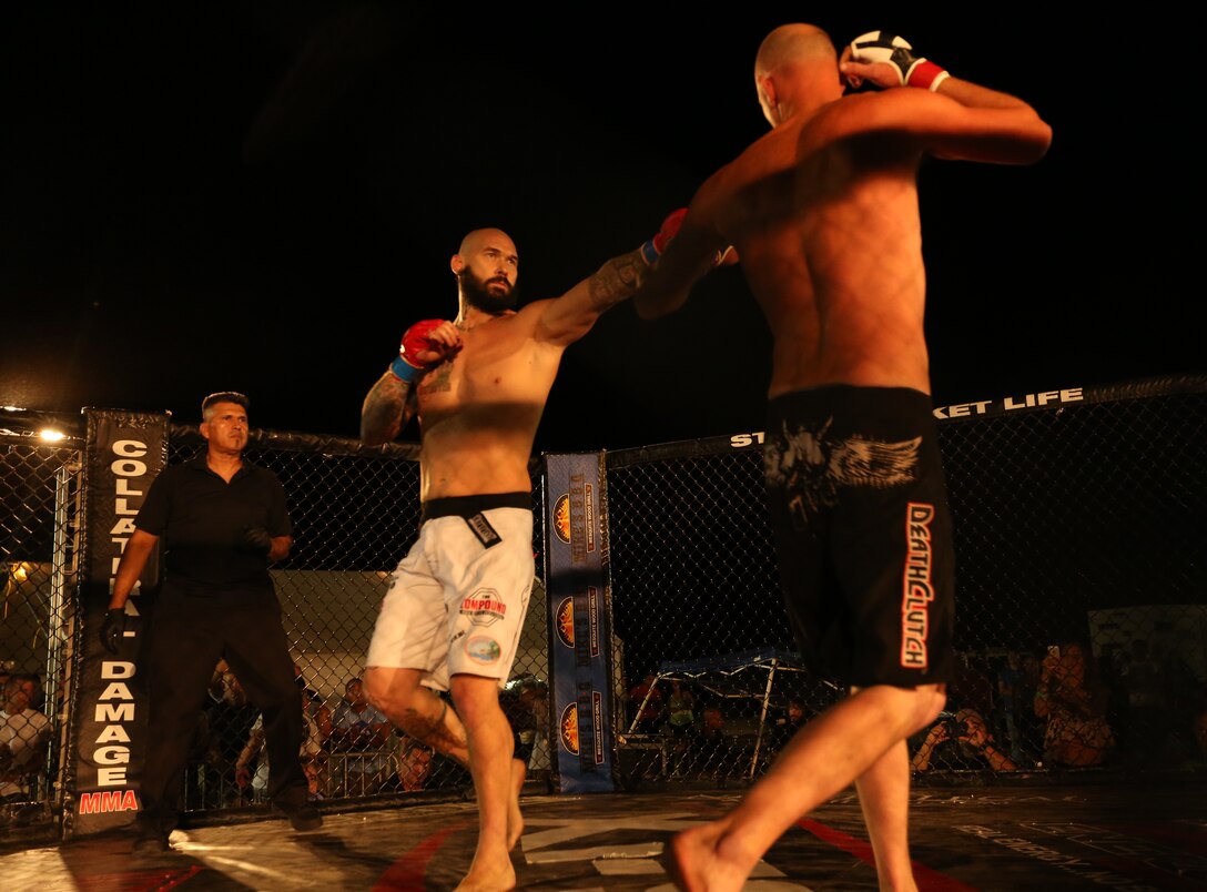 Sean Loeffler, fighter, The Compound MMA, touches gloves with Travis McCullogh, independent fighter, during Summer Fight Night V at Del Valle Field, June 20, 2014. Fighters were subject to three-round matches, unless one forced the other to submit or knocked them out.