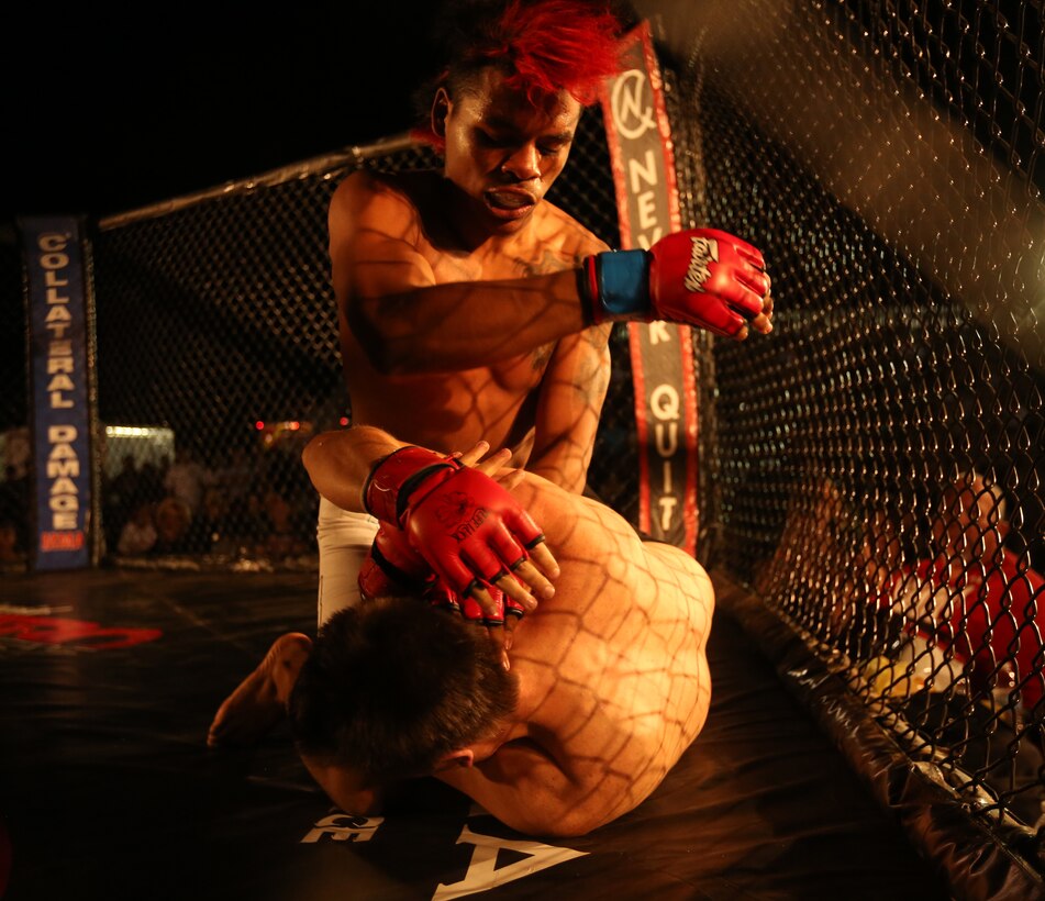 Chris "Taco" Padilla, fighter, Hardbody MMA, strikes Kenny Wyckoff, fighter, Fight Ugly MMA, during Summer Fight Night V at Del Valle Field, June 20, 2014. "This was my first time in Twentynine Palms," Padilla said. "Fighting for the service members is an honor. They're the reason we are here."