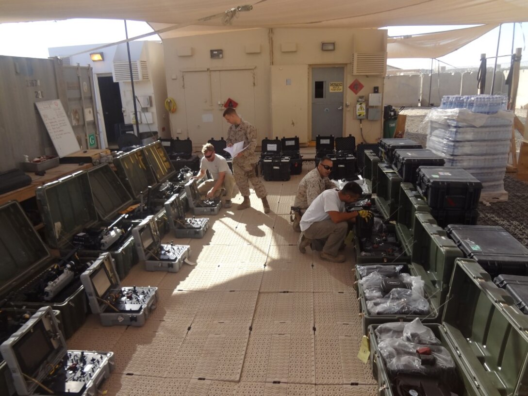 Courtesy photo - Marines, government civilians and contractors with Logistics Command Forward inventory communication equipment during their deployment to Camp Leatherneck, Helmand province, Afghanistan. The unit was comprised of an effective and efficient staff that allows them to easily expand or contract logistical support to meet the requirements of the operational commander with minimal resources being pulled from the operating forces, prior to their flag-folding ceremony, June 1, 2014.