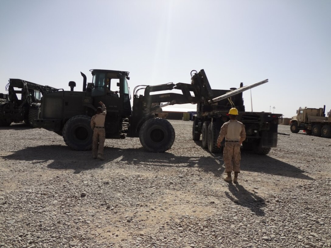 Courtesy photo - Marines with Logistics Command Forward unload equipment from a truck during their deployment to Camp Leatherneck, Helmand province, Afghanistan. The unit was comprised of an effective and efficient staff that allows them to easily expand or contract logistical support to meet the requirements of the operational commander with minimal resources being pulled from the operating forces, prior to their flag-folding ceremony, June 1, 2014.