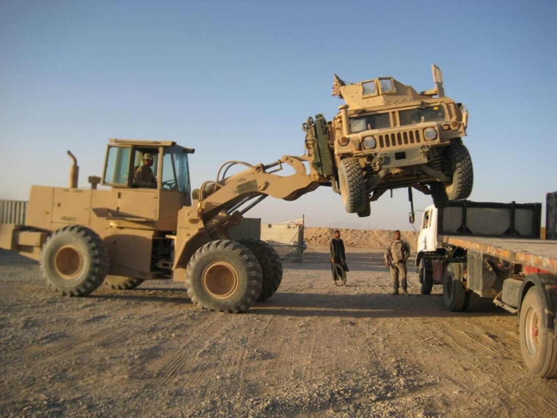 Courtesy photo - Marines with Logistics Command Forward load a High Mobility Multipurpose Wheeled Vehicle onto a truck during their deployment to Camp Leatherneck, Helmand province, Afghanistan. LOGCOM Forward is responsible for redeploying tactical vehicles and gear to Marine Corps Logistics Base Albany, Ga., for reset and reconstitution as deployed units begin to redeploy home, prior to their flag-folding ceremony, June 1, 2014.