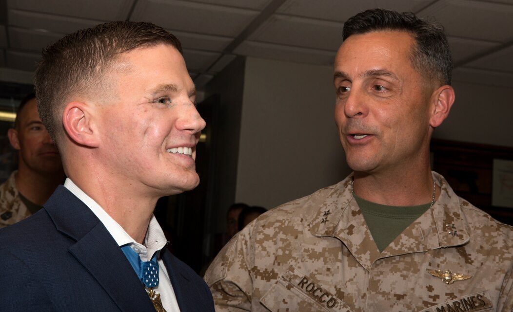 Cpl. William “Kyle” Carpenter, left, Medal of Honor recipient, speaks to Maj. Gen. Michael Rocco, right, 3rd Marine Aircraft Wing commanding general, before a 3rd Marine Aircraft Wing evening colors ceremony held to honor the spirit of the noncommissioned officer aboard Marine Corps Air Station Miramar, Calif., June 23. Carpenter attended the ceremony as the guest of honor and spoke to gathered attendees about what a noncommissioned officer was to him.