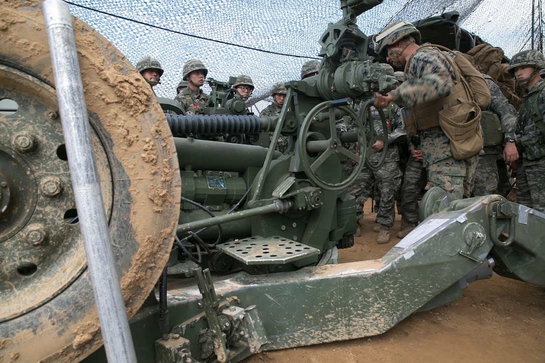 U.S. Marine Sgt. Michael D. Gutierrez, right, demonstrates how to use the M777A2 lightweight 155 mm howitzer to Republic of Korea Marines June 12 at Warrior Base, Munsan, South Korea, during the Korean Marine Exchange Program 14-7. KMEP is a series of exercises conducted regularly between ROK and U.S. Marines Corps to increase interoperability and combined capability. Gutierrez is a Detroit, Michigan native and field artillery cannoneer with 3rd Battalion, 12th Marine Regiment, 3rd Marine Division, III Marine Expeditionary Force. (U.S. Marine Corps Photo by Lance Cpl. Thor J. Larson/ Released)