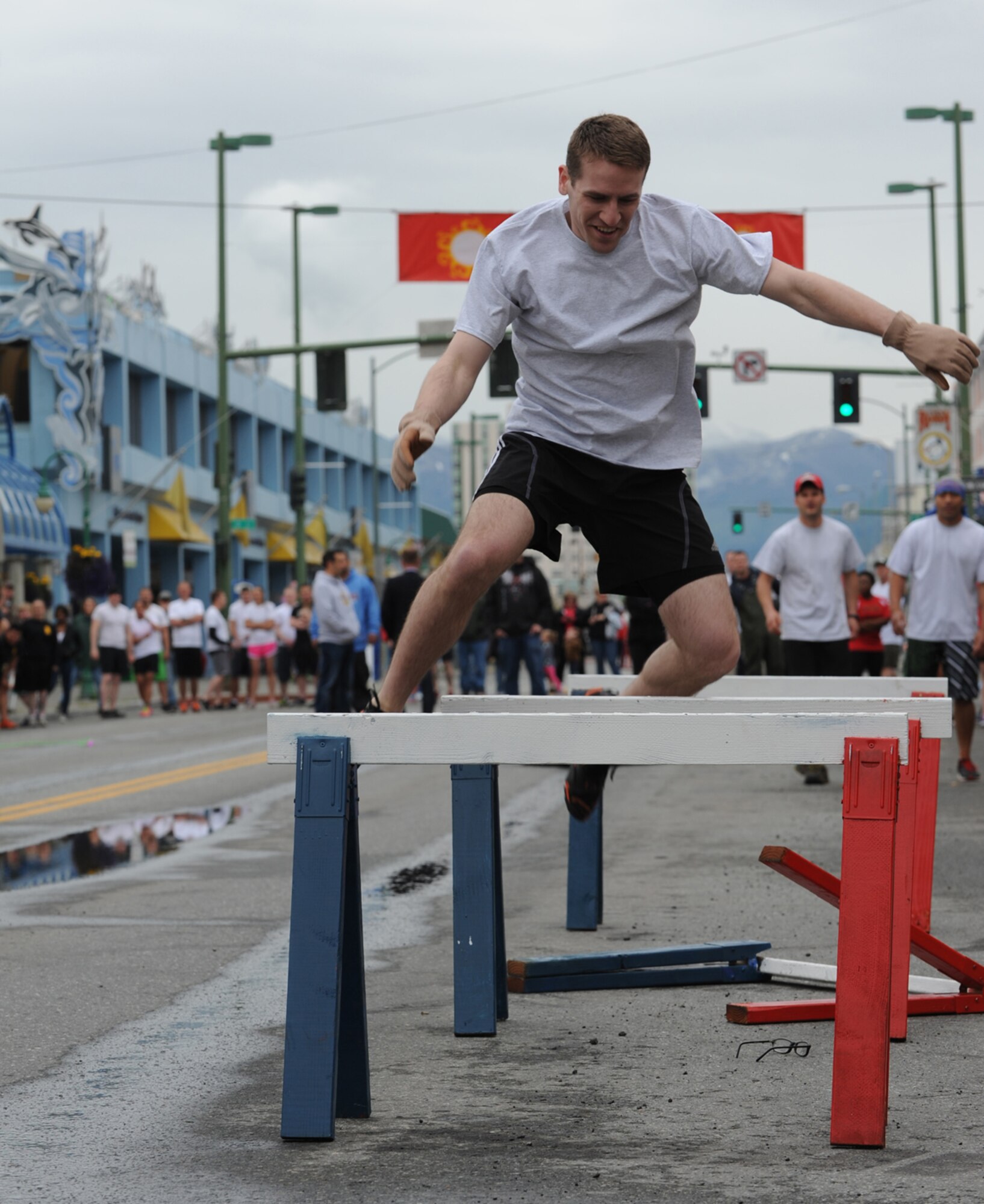 ANCHORAGE, Alaska ??? Senior Airman Kenneth Mendenhall jumps a hurdle after losing his glasses during the 2014 Hero Games on 4th Avenue in downtown Anchorage June 21, 2014. This year the Hero Games featured teams from the Army, Air Force, Army National Guard, Air National Guard and the Coast Guard Sector Anchorage. (U.S. Air Force photo/Senior Airman Omari Bernard)