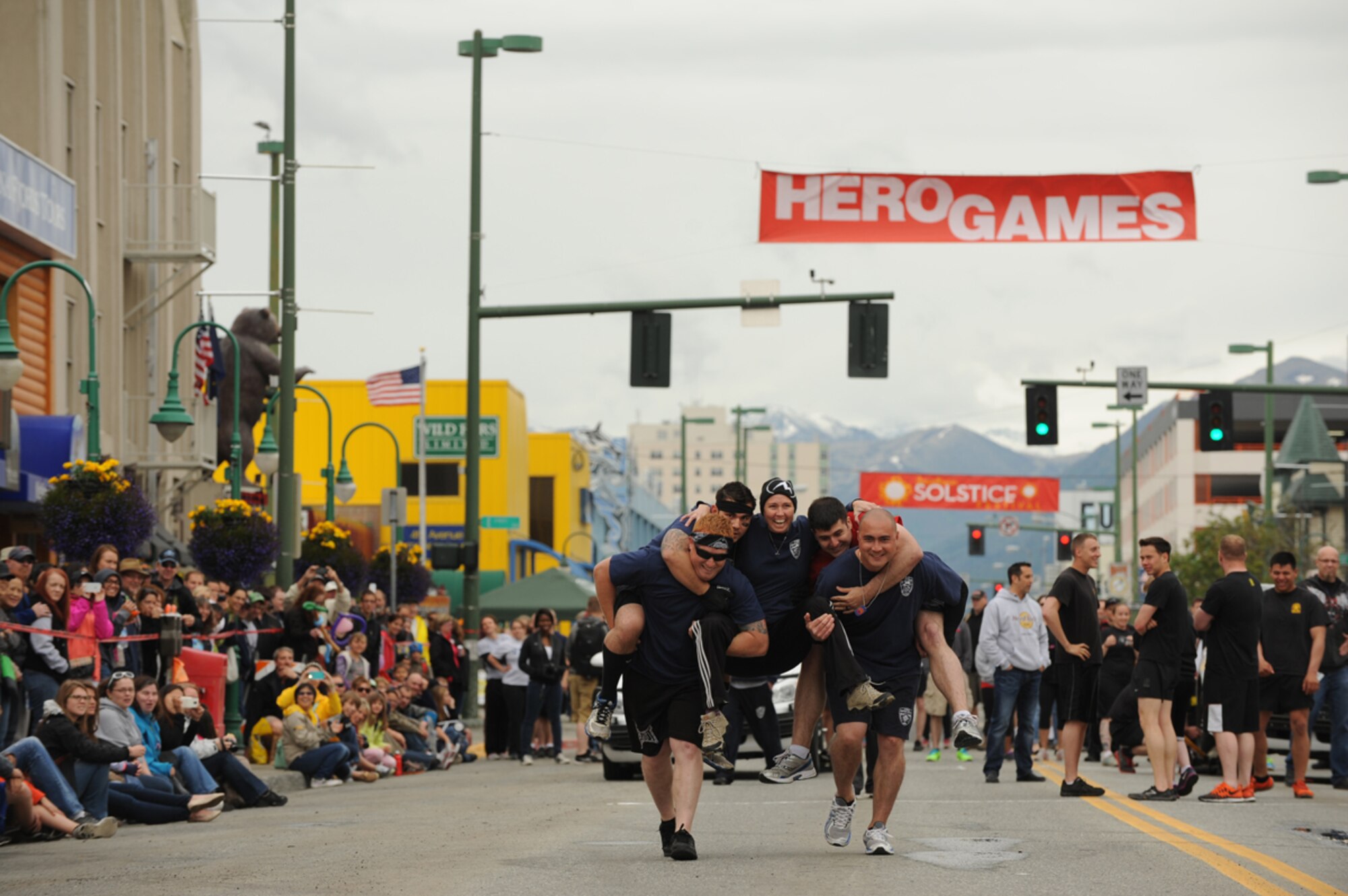 ANCHORAGE, Alaska ??? The Joint Base Elmendorf-Richardson Fire Dogs, 673d Civil Engineer Squadron, complete the team walk challenge during the 2014 Hero Games on 4th Avenue in downtown Anchorage June 21, 2014. The team walk consisted of five players, but only two were able to touch the ground. (U.S. Air Force photo/Senior Airman Omari Bernard)
