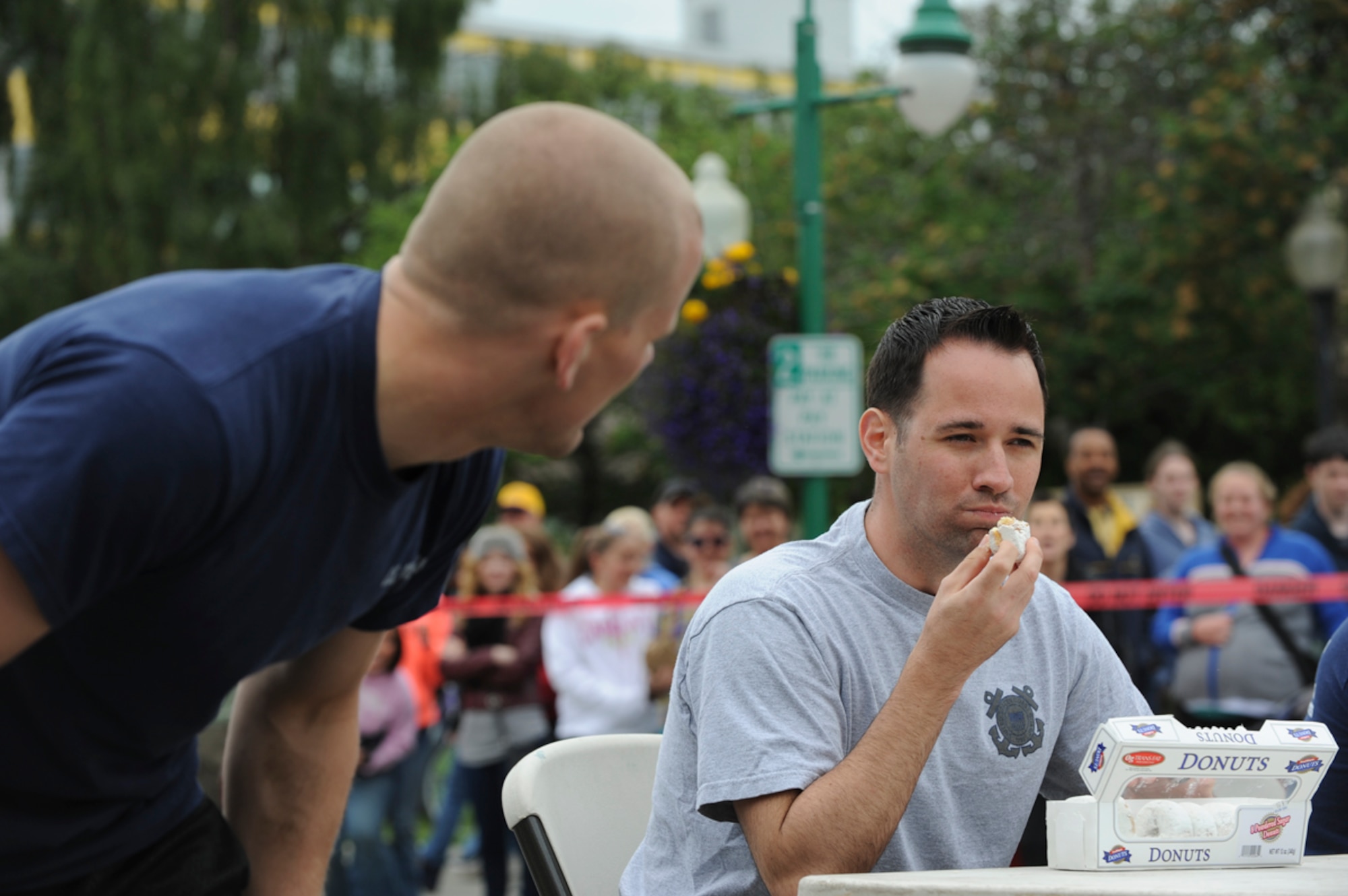 ANCHORAGE, Alaska ? U.S. Coast Guardsman Petty Officer 3rd Class Nathan Lewis chews a donut before whistling during the 2014 Hero Games on 4th Avenue in downtown Anchorage June 21, 2014. The donut-eating trial was part of the endurance course, where competitors also had to whistle after eating a powdered donut with no water. (U.S. Air Force photo/Senior Airman Omari Bernard)