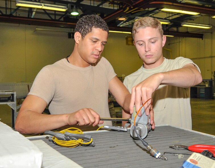 Airmen 1st Class Karl Reid and Tyler Reid, 2nd Munitions Squadron missile maintenance technicians, perform a pyrotechnic device replacement on part of an air-launched cruise missile on Barksdale Air Force Base, La., June 19, 2014. The pyrotechnic device ensures that flight control surfaces, such as the wings or fin of the ALCM, deploy after being launched from a B-52H Stratofortress. (U.S. Air Force photo/Airman 1st Class Benjamin Raughton)