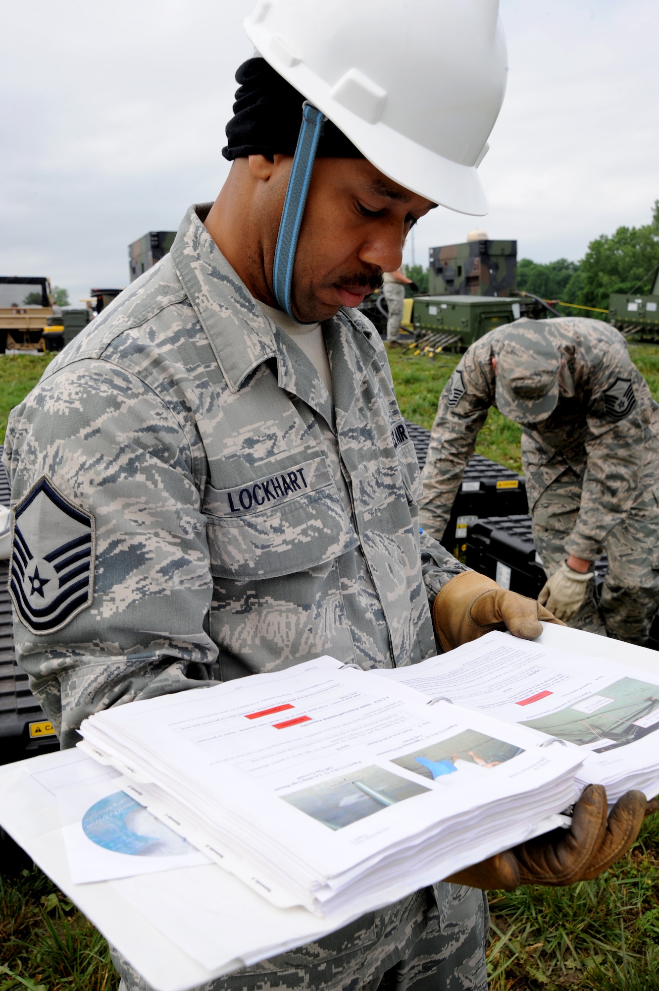 Master Sgt. Ervin Lockhart, 239th Combat Communications Squadron NCO in-charge of radio frequency transmissions, follows a technical order to build a satellite during a simulated deployment to Whiteman Air Force, Mo., June 11, 2014. The 239th CCS deploys with their own power plant and satellite allowing effective internet communications for an entire wing. (U.S. Air Force photo by Senior Airman Bryan Crane/released)