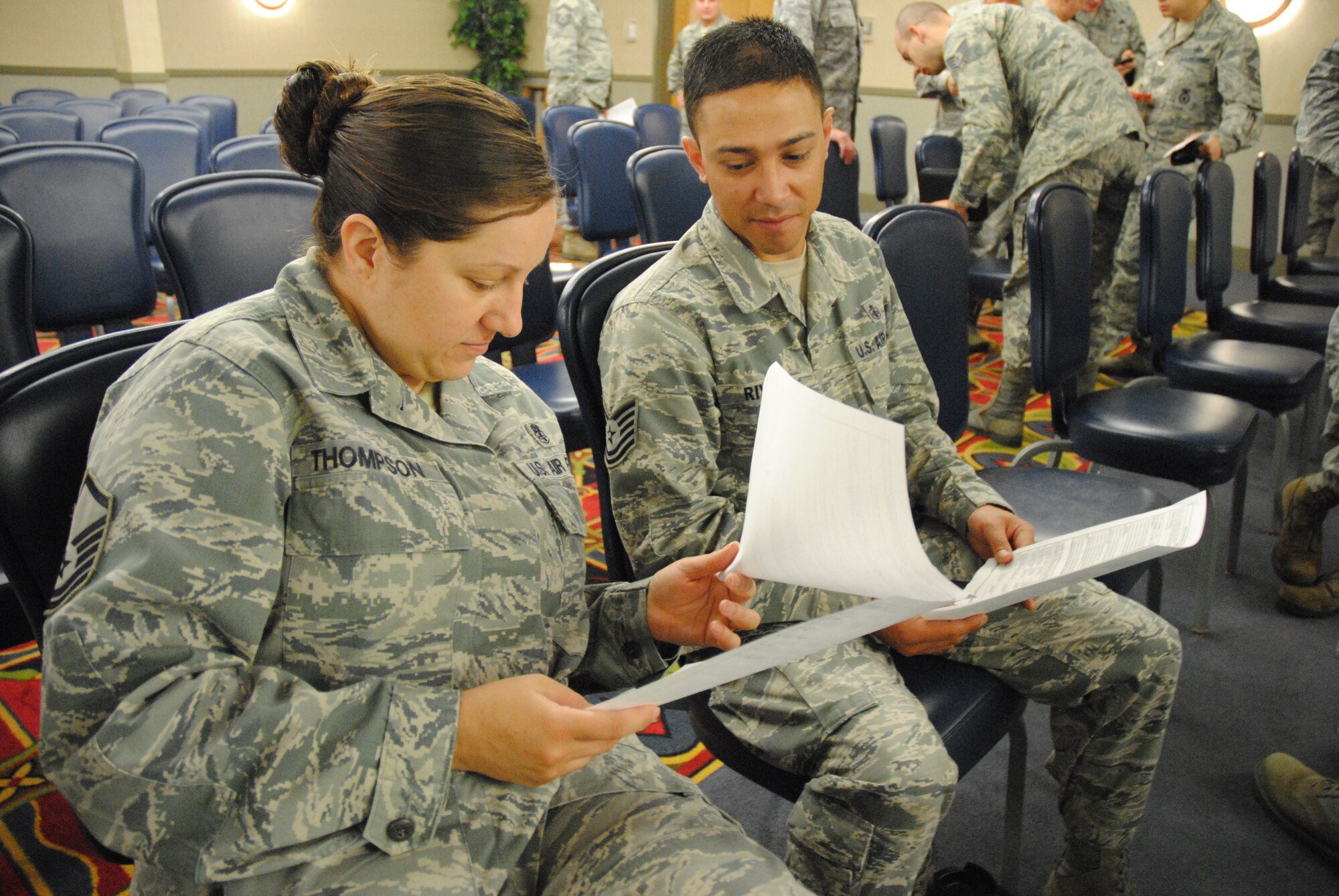 Master Sgt. Becky Thompson and Tech. Sgt. Juan Rivera of the 319th Medical Support Squadron familiarize themselves with forms used for the Airman Comprehensive Assessment after a mandatory town hall meeting for all supervisors,  June 25, 2014, at the Northern Lights Club on Grand Forks Air Force Base, N.D. The new evaluation system is scheduled to go into effect July 1, 2014. (U.S. Air Force photo/Staff Sgt. Luis Loza Gutierrez)