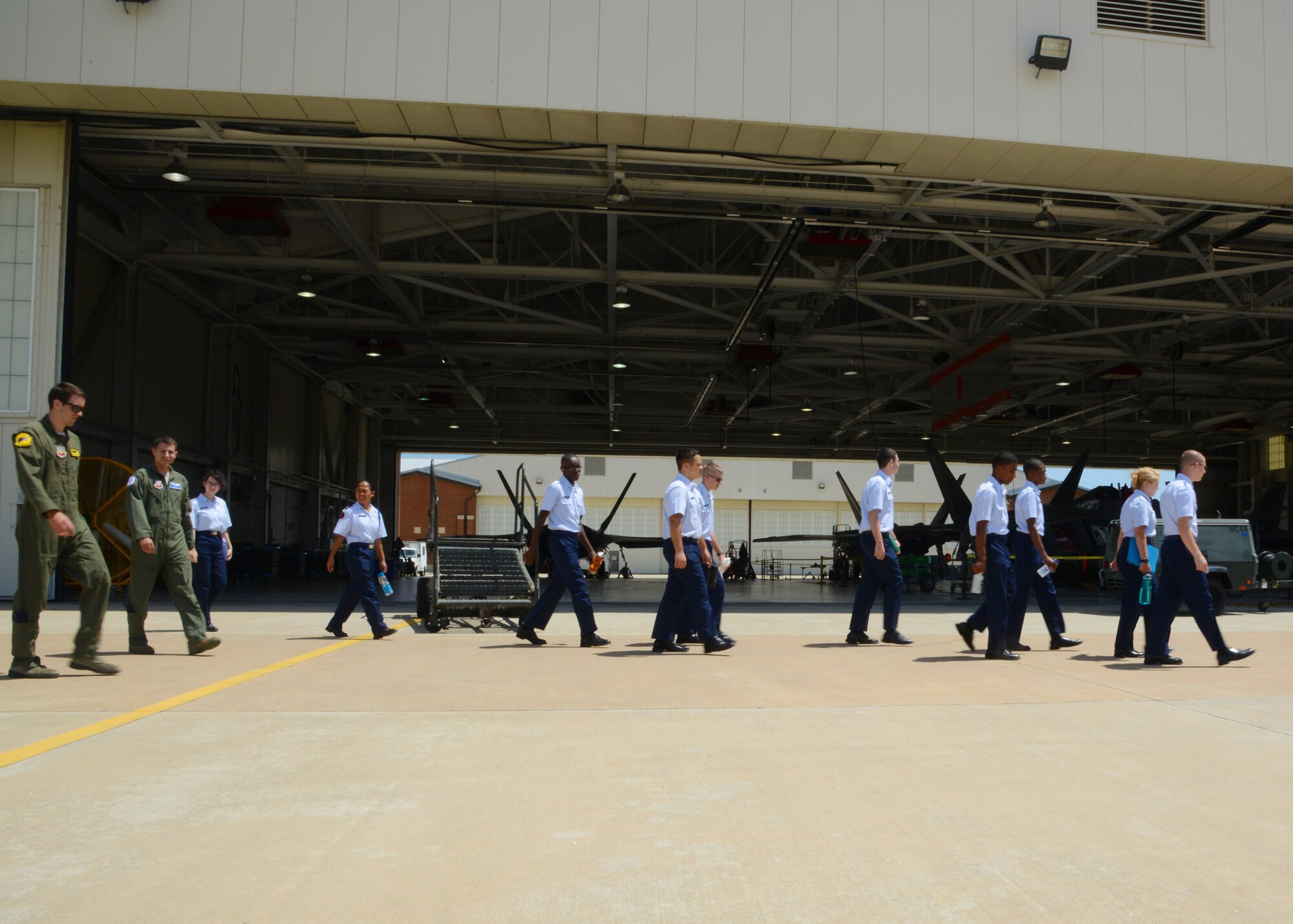 U.S. Air Force Junior ROTC cadets walk past the 94th Fighter Squadron’s maintenance hangar during the annual Shadow Day at Langley Air Force Base, Va., June 24, 2014. The shadow day was part of a week-long Air Force Junior ROTC Summer Leadership School at Langley, which also includes drill, academic testing, physical fitness tests, and daily room and uniform inspections. (U.S. Air Force photo by Senior Airman Jason J. Brown/Released)