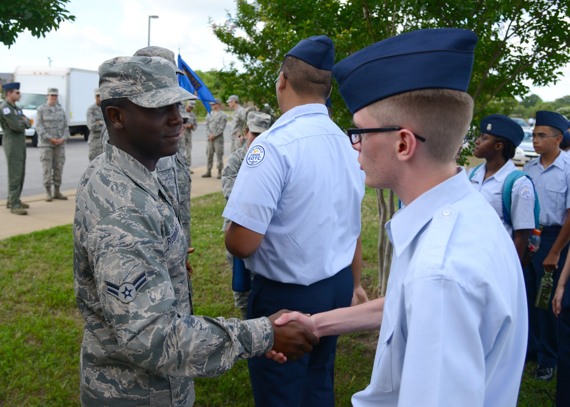 U.S. Air Force Airman 1st Class Alexander Rodrigues, 439th Supply Chain Operations Squadron A-10 specialist, greets Air Force Junior ROTC cadets at pick-up during the annual Shadow Day at Langley Air Force Base, Va., June 24, 2014. Rodrigues said he wanted to be a “positive influence on youth in the community” and answer cadets’ questions about Air Force life. (U.S. Air Force photo by Senior Airman Jason J. Brown/Released)