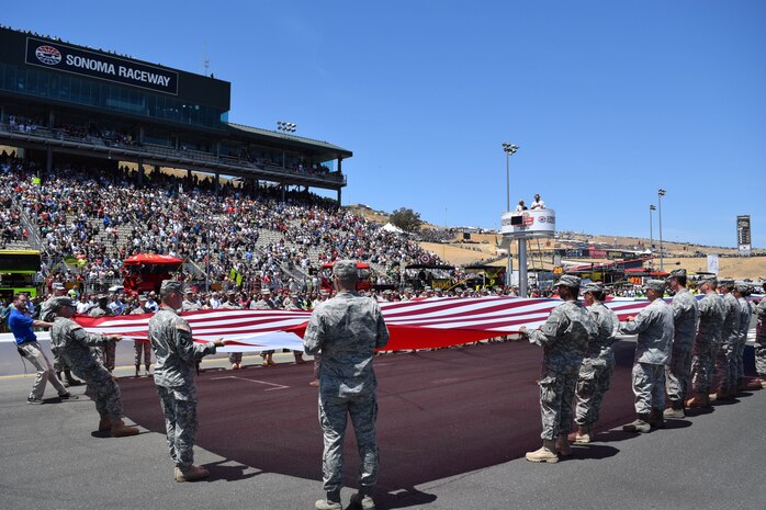 Thirty Airmen from Beale Air Force Base teamed with Army soldiers to present a large American flag during the singing of the National Anthem prior to the NASCAR race at Sonoma Raceway, Sonoma, Calif., June 22, 2014. The flag presentation was featured on national television. (U.S. Air Force photo by Capt. Brian Wagner/Released)