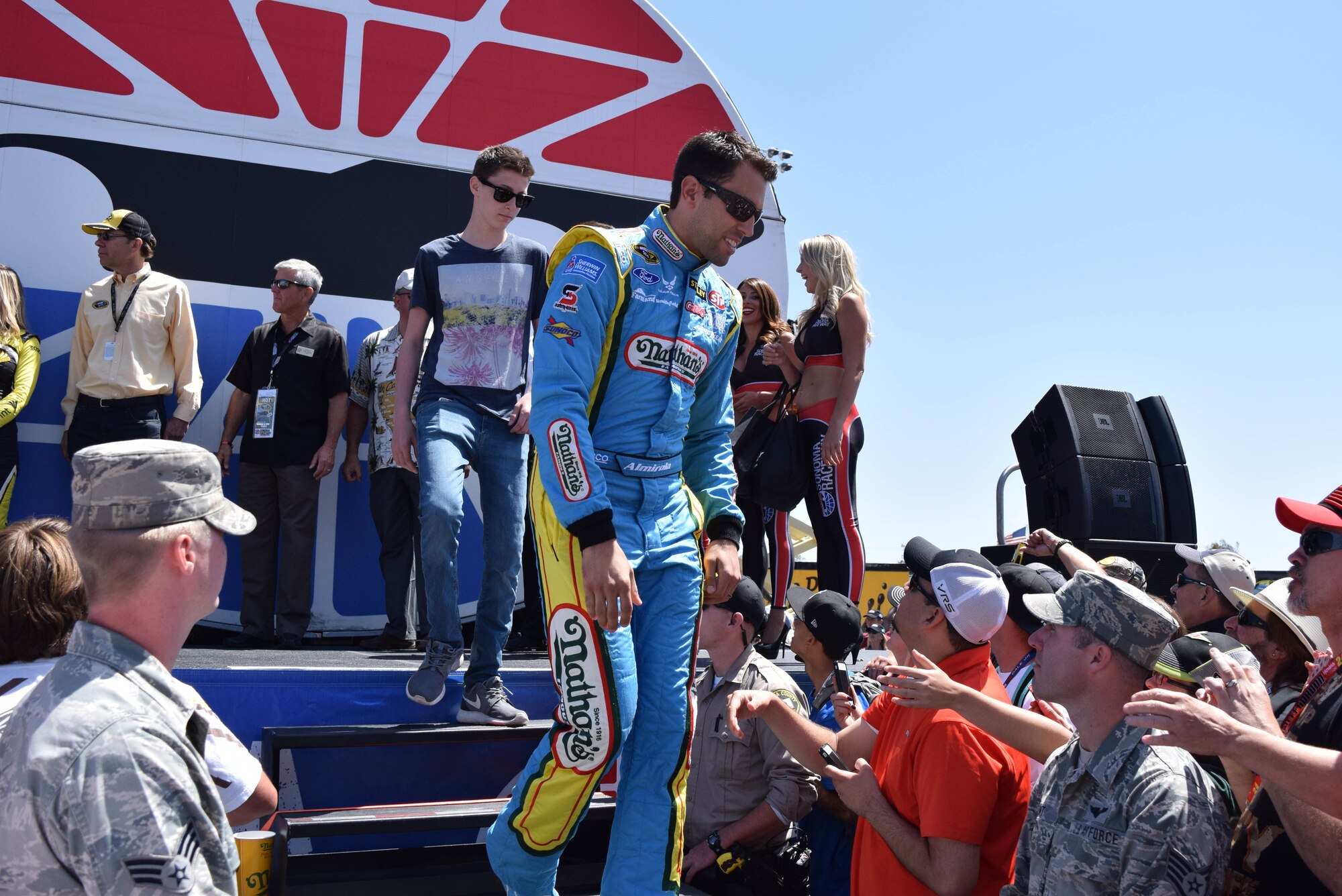 Two Airmen from Beale Air Force Base stand along the elevated walkway as NASCAR driver Aric Almirola, makes his way through the crowd June 22, 2014. Eight Beale Airmen got the opportunity to line the walkway during driver introductions prior to the NASCAR race at Sonoma Raceway, Sonoma, Calif. (U.S. Air Force photo by Capt. Brian Wagner/Released)