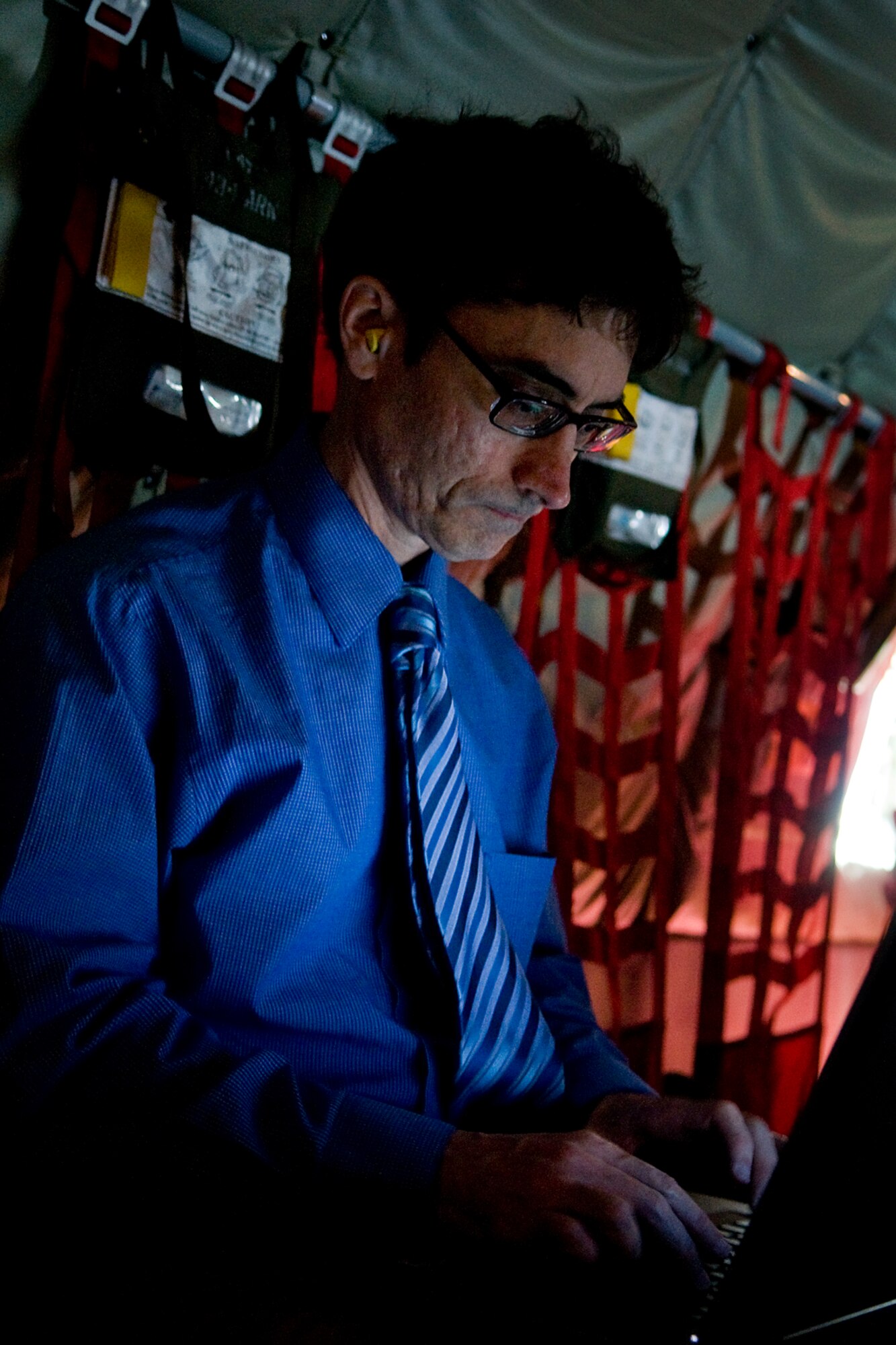 Barrie Barber, a reporter with the Dayton Daily News, writes on his laptop during a Wale Aliyu, a combined media flight hosted by both the 434th Air Refueling Wing from Grissom Air Reserve Base, Ind., and the 445th Airlift Wing at Wright-Patterson Air Force Base, Ohio. The 434th ARW is the largest KC-135R unit in the Air Force Reserve Command, and the 445th AW C-17 flies the newest and most flexible cargo aircraft in the airlift force. (U.S. Air Force photo/Senior Airman Jami K. Lancette)