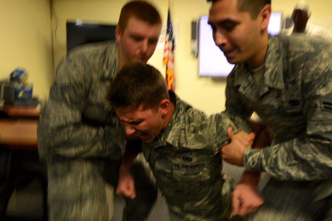 U.S. Air Force Airman 1st Class Michael Cossaboom, 20th Fighter Wing Public Affairs photojournalist, falls to the ground while being Tasered at Shaw Air Force Base, S.C., June 25, 2014. As part of security forces augmentee training, Cossaboom along with eight other Airmen experienced a Taser up to 50,000 volt, weapons firing and pepper spray. (U.S. Air Force photo by Airman 1st Class Jensen Stidham/Released)