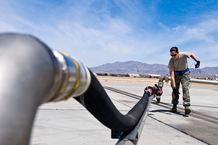 Senior Airman Elizabeth Bingham, 419th Logistics Readiness Squadron, Hill Air Force Base, Utah fuels journeyman, moves a ground clamp attached to a pantograph June 20, 2014, at Nellis AFB, Nev. A pantograph is utilized for fueling aircraft while the engines are running. (U.S. Air Force photo by Senior Airman Christopher Tam)
