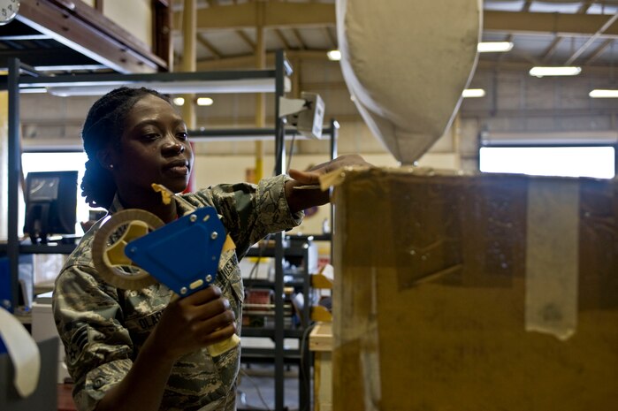 Senior Airman Faith Oladele, 419th Logistics Readiness Squadron, Hill Air Force Base, Utah traffic management craftsman, tapes a box together to be shipped June 20, 2014, at Nellis Air F Base, Nev. The 419th LRS is part of the 419th Fighter Wing an Air Reserve Component was at Nellis to participate in training with the 99th LRS for two weeks. (U.S. Air Force photo by Senior Airman Christopher Tam)