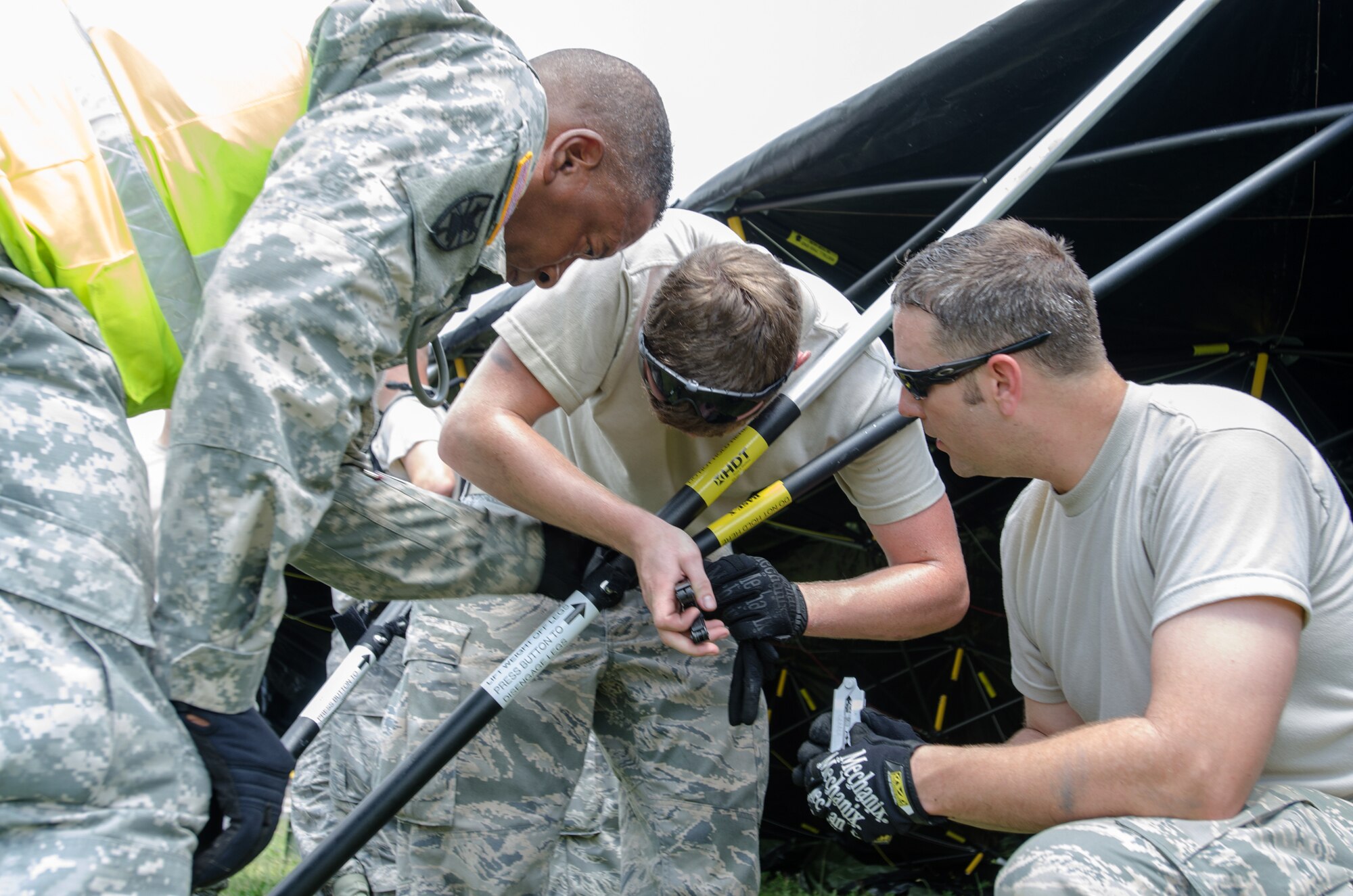 Personnel from the Kentucky Air National Guard’s 123rd Contingency Response Group and the U.S. Army’s 688th Rapid Port Opening Element work together to erect a Base X tent at Fort Campbell, Ky., on June 17, 2014, while participating in at Capstone '14, a homeland earthquake-response exercise. The 123rd CRG joined with the 688th RPOE to operate a Joint Task Force-Port Opening from June 16 to 19, 2014. (U.S. Air National Guard photo by Master Sgt. Phil Speck)