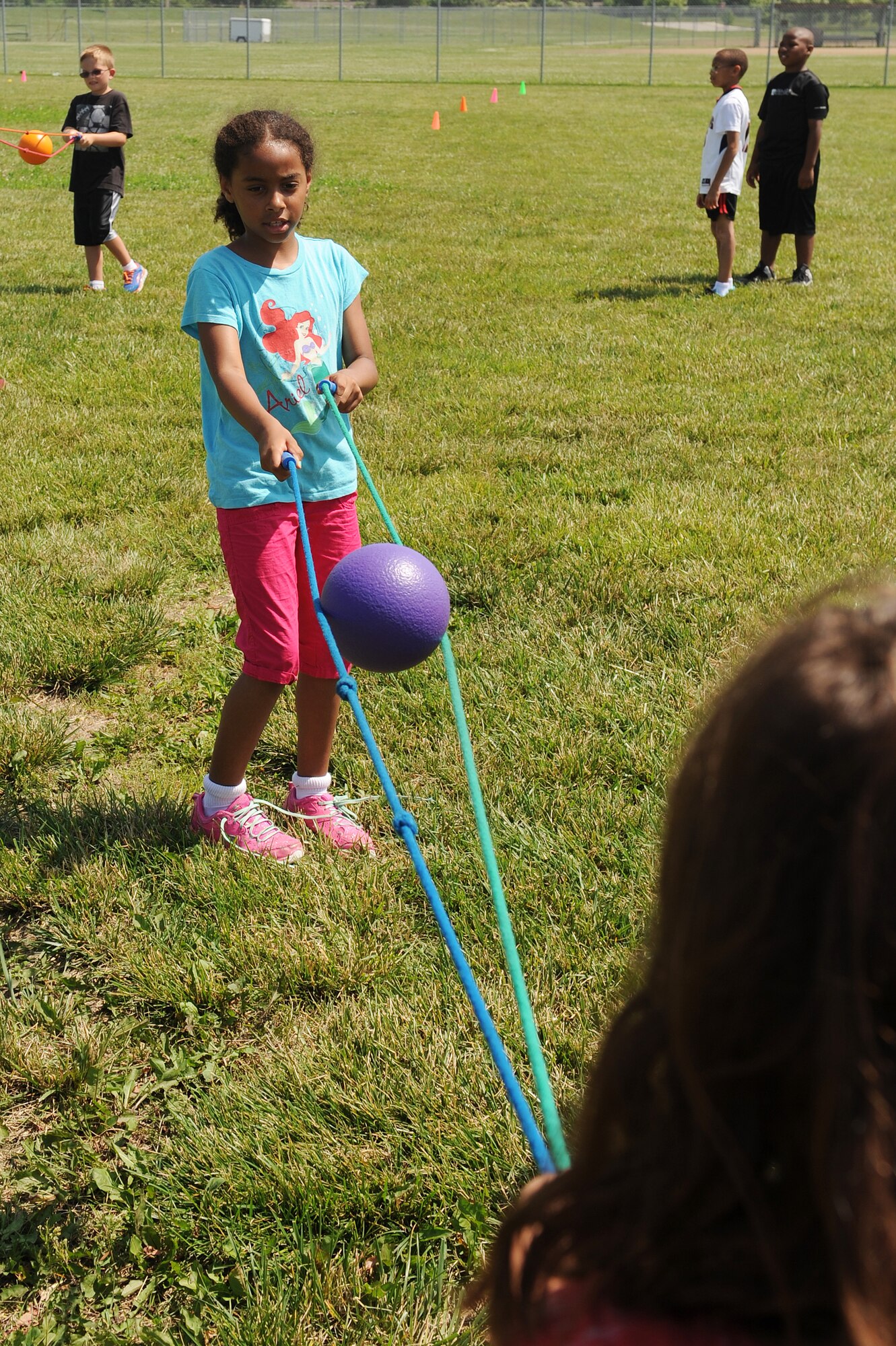 Ariela Wilson and her partner balance a ball between two jump ropes during a race at Scott Air Force Base, Ill., June 18, 2014.  Competitors tried to keep the ball from falling, while walking to a cone and back.  The Youth Center hosted the 2014 Olympic Celebration to teach children about the Olympics and it’s ideals, including sportsmanship, fair play and perseverance.  (U.S. Air Force photo by Staff Sgt. Maria Bowman)