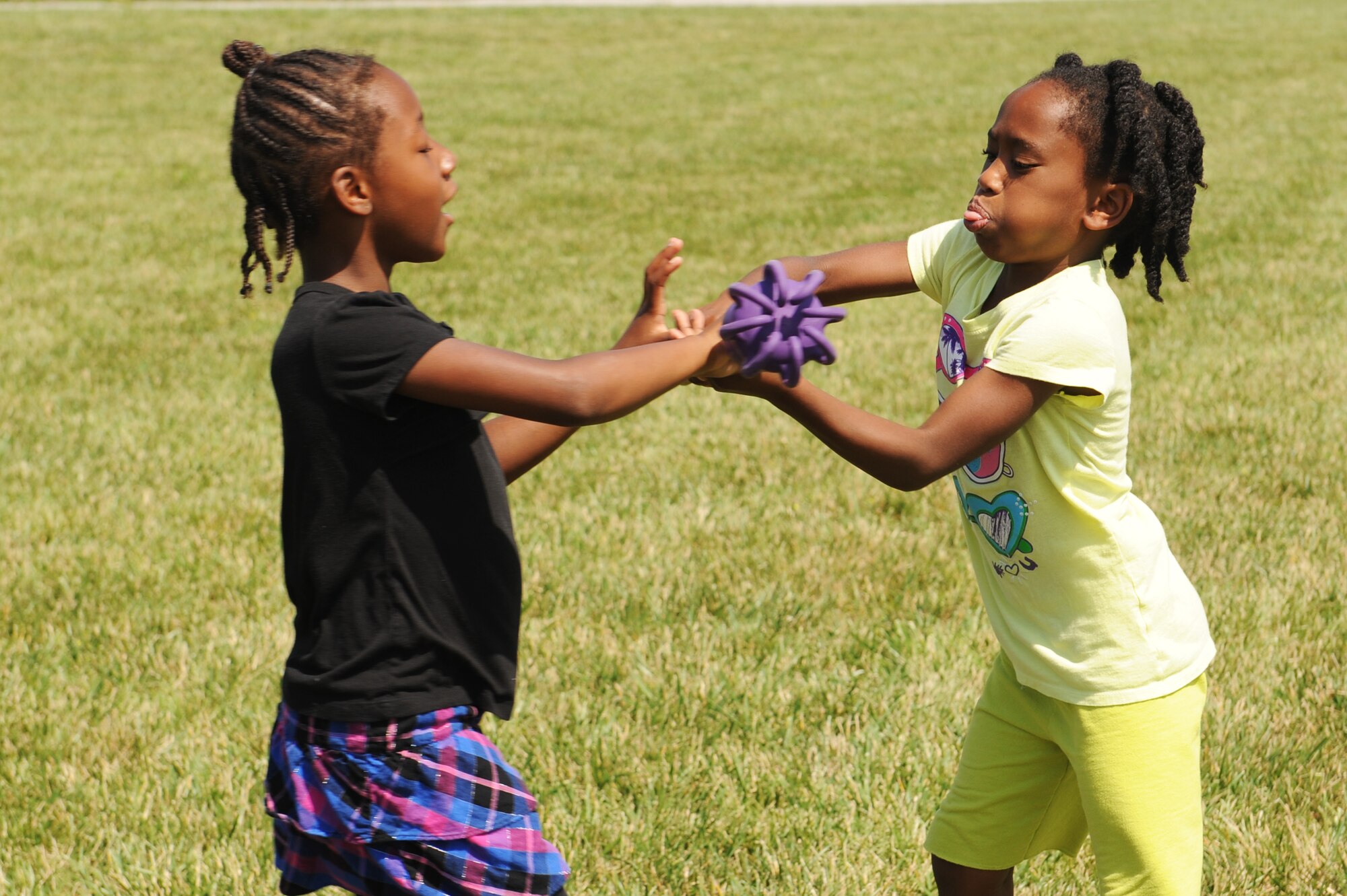 Samantha Evans, left passes the baton to Azeal Hopkins during the relay race for the 2014 Olympic Celebration at Scott Air Force Base, Ill., June 18, 2014.  The Youth Center hosted this event to teach children about the Olympics and encourage the children to compete as part of a team and as an individual.  (U.S. Air Force photo by Staff Sgt. Maria Bowman)