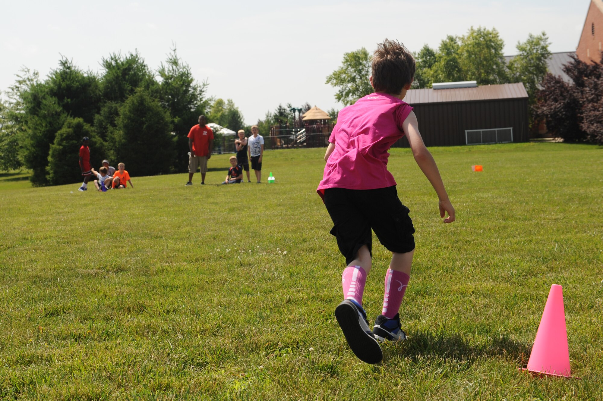 Joey Aamodt sprints back to his teammates during a race at Scott Air Force Base, Ill., June 18, 2014.  The Youth Center participated in the 2014 Olympic Celebration June 17-19.  Throughout the week, participants competed in a variety of challenges, including shot put, relays and distance tosses.  (U.S. Air Force photo by Staff Sgt. Maria Bowman)