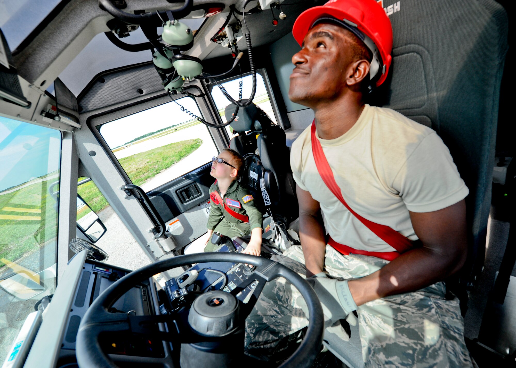 Senior Airman Jeremy McLaurin, 22nd Civil Engineer Squadron firefighter driver operator, shows Claire Stewart, Team McConnell’s “Pilot for a Day,” how to operate the snozzle inside a striker fire vehicle, June 20, 2014, at McConnell Air Force Base, Kan. Claire was selected to be a “Pilot for a Day,” a 22nd Air Refueling Wing program held to give medically-challenged children a day of fun events and activities. (U.S. Air Force photo/Airman 1st Class John Linzmeier)