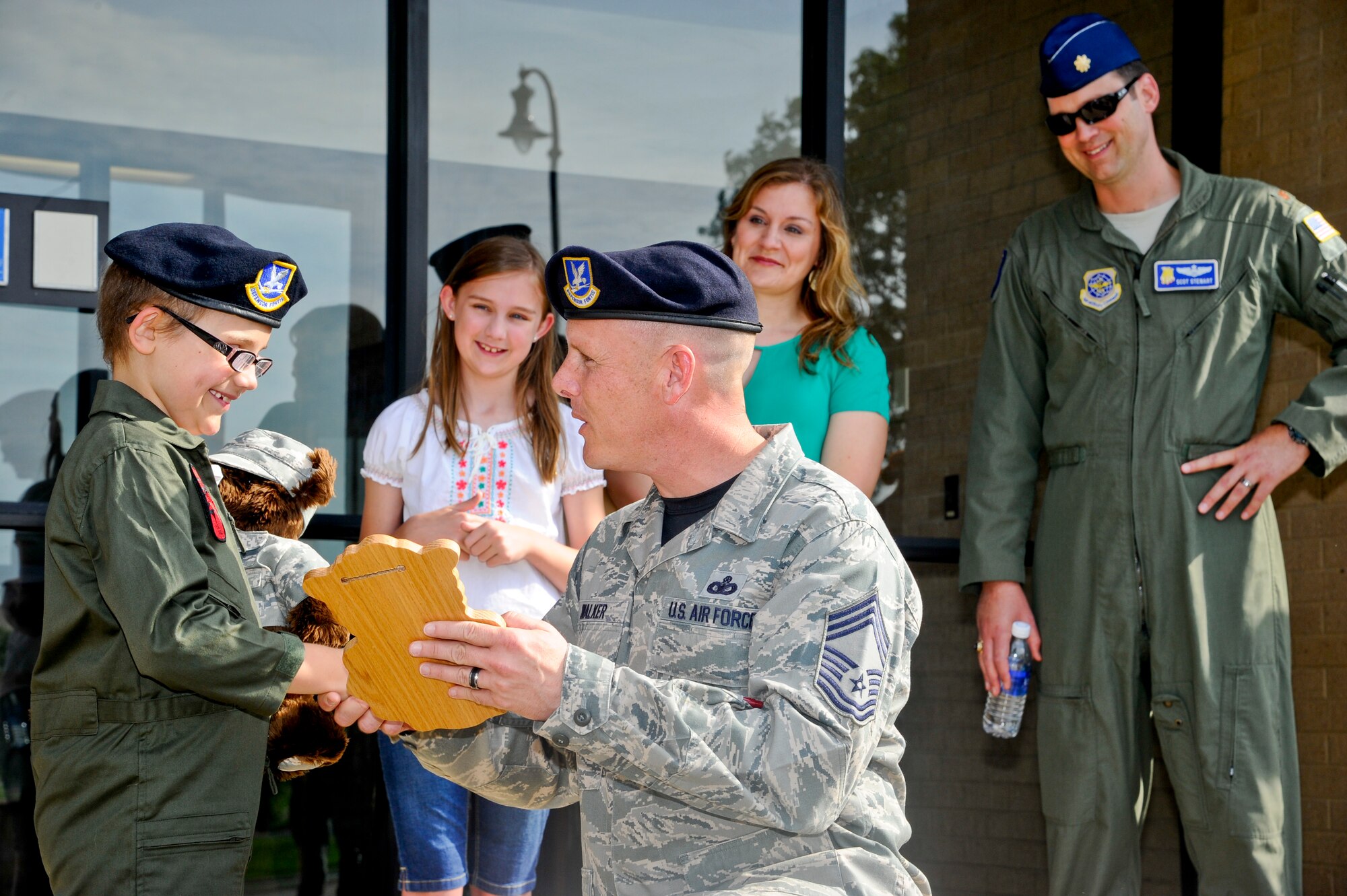 Chief Master Sgt. Christopher Walker, 22nd Security Forces Squadron superintendant, hands Claire Stewart a plaque in front of the 22nd SFS building, June 20, 2014, at McConnell Air Force Base, Kan. Claire was selected to be a “Pilot for a Day,” a 22nd Air Refueling Wing program held to give medically-challenged children a day of fun events and activities. (U.S. Air Force photo/Airman 1st Class John Linzmeier)